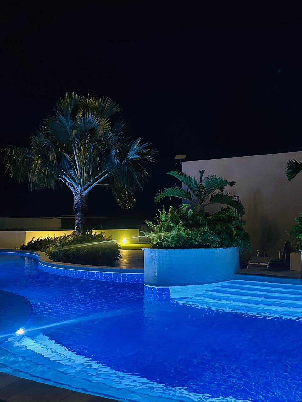 Night view of the illuminated pool at Panorama Residences.